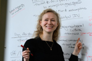 Mariya Grinberg in front of a white board